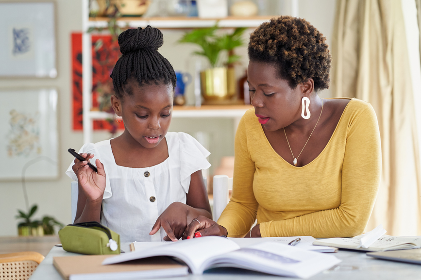 A mother and daughter work on homework or home schooling at home.